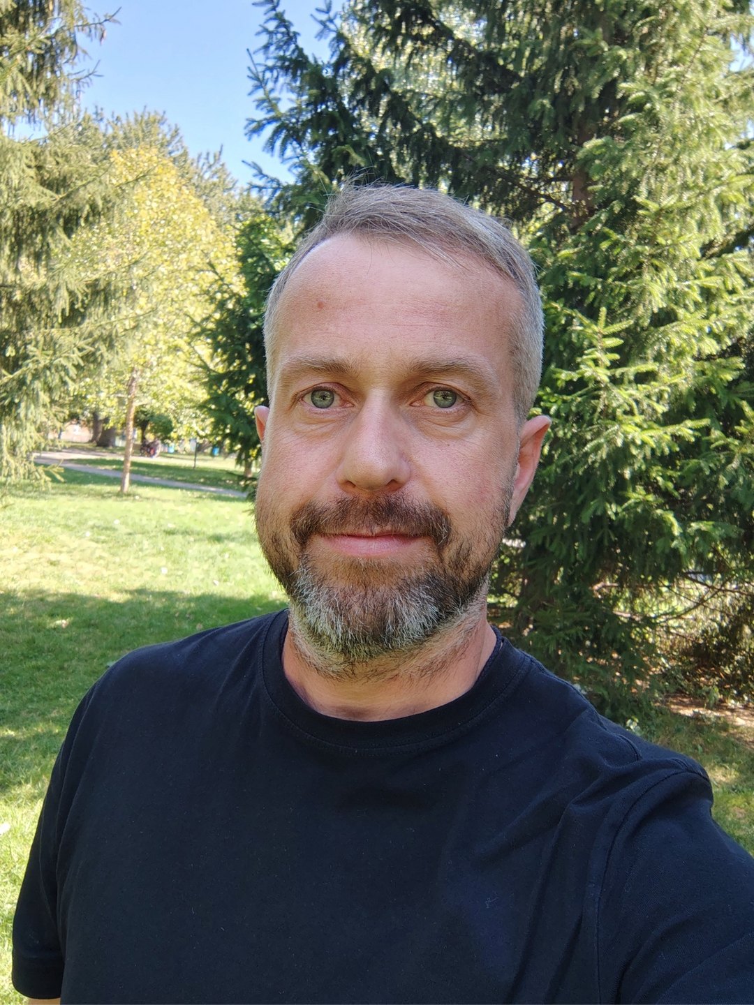 Сергей Ермолин в парке на фоне елей